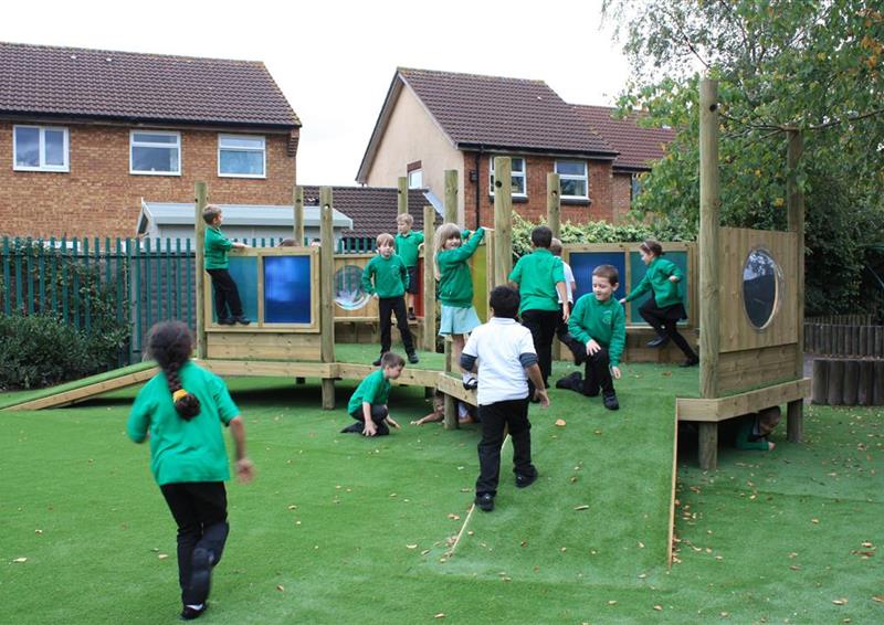 12 children playing on our imagination station, 3 children are climbing along the side whilst the ret of the children are running around on top of the equipment.